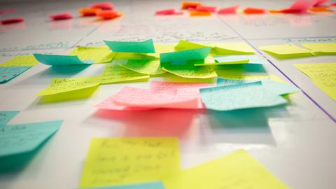 multi-colored stickie notes in groups stuck to a white board - photo Greg Aimo