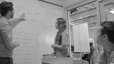 3 teaching staff developing ideas on a white board - photo Casey Smerczynski